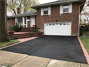 split level house jericho asphalt driveway and red brick steps platform light pier post planter wall